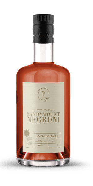 A clear glass bottle with red liquid and a beige label titled Sandymount Negroni